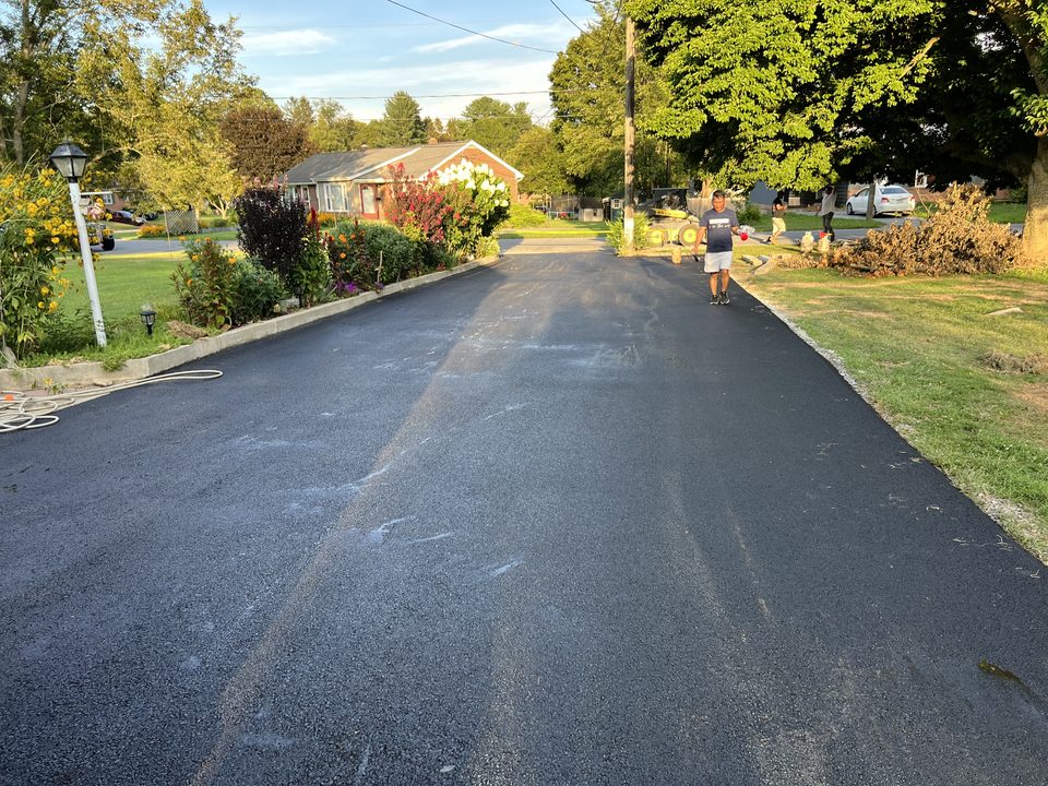 Freshly paved asphalt driveway in New Hampshire at golden hour
