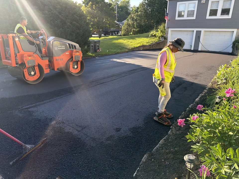 AC Asphalt crew compacting a new driveway with a roller in New Hampshire