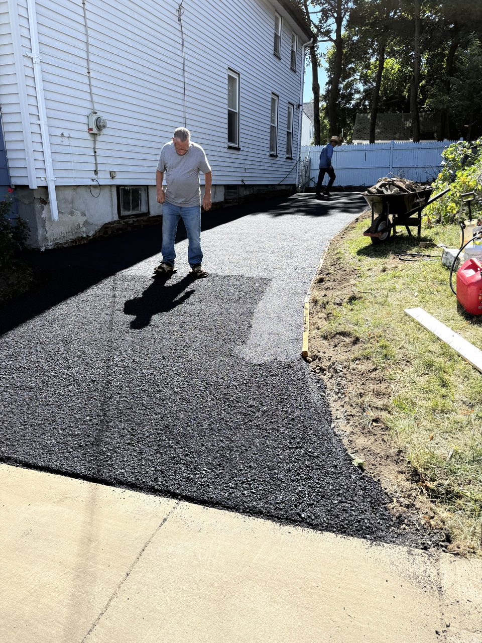 Asphalt paving process underway on a driveway